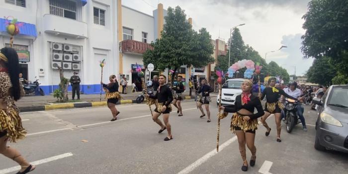 Grupos de personas haciendo presentación en desfile del mes del orgullo LGBTIQ+