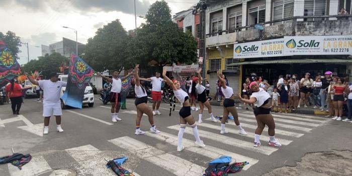 Grupos de personas haciendo presentación en desfile del mes del orgullo LGBTIQ+