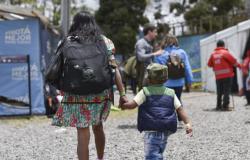 Indígena embera camina con su hijo de la mano cargando un morral en Bogotá