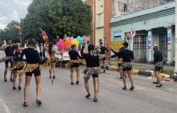 Grupos de personas haciendo presentación en desfile del mes del orgullo LGBTIQ+